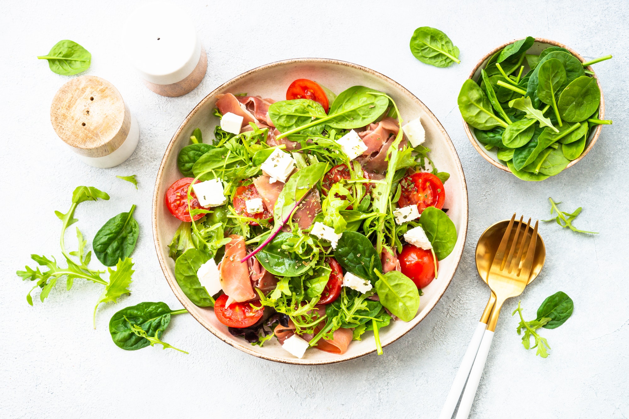 Healthy salad with green leaves, tomatoes and jamon.